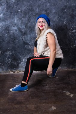 Spor tarzı giyinmiş çekici, tombul bir kadın.