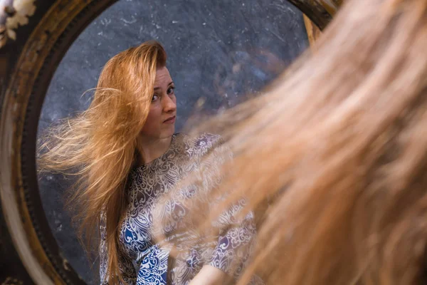 Vrolijke middelbare leeftijd vrouw kijkt in vintage stijl spiegel — Stockfoto