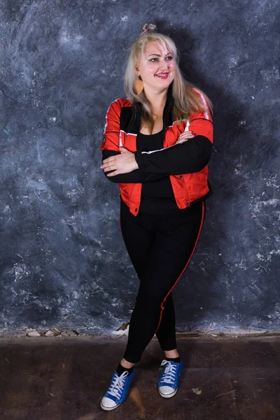 Spor tarzı giyinmiş çekici, tombul bir kadın.