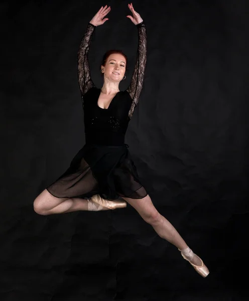 Hermosa bailarina estudio retrato saltando sobre fondo negro. — Foto de Stock