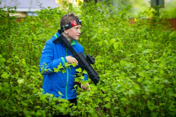 Chłopiec z bronią bawiący się w laser tag — Zdjęcie stockowe