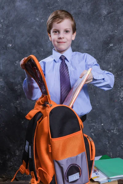 Anak sekolah yang lucu mengenakan kemeja dan dasi dengan potret studio tas sekolah. — Stok Foto