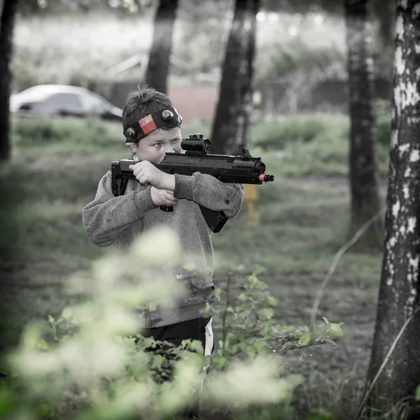 Rapaz com uma arma a jogar laser tag — Fotografia de Stock