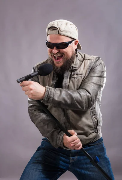 Cantor de rock emocional barbudo com retrato de estúdio micriphone. — Fotografia de Stock