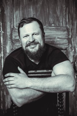 Olgun sakallı adam klasik kapının arkasında oturuyor.