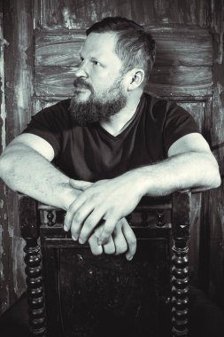 Olgun sakallı adam klasik kapının arkasında oturuyor.