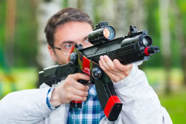 Muž míří pistolí laser tag zařízení. — Stock fotografie