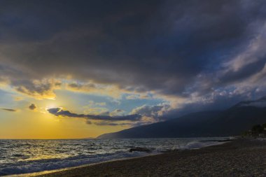 Gün batımında dalgalarla güzel bir kıyı sahnesi