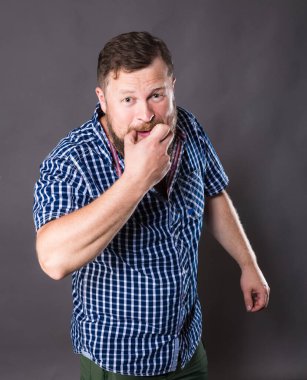 Joyful bearded man in shirt whistling studio portrait clipart