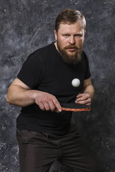 Homem barbudo em destaque joga retrato de estúdio de tênis de mesa. — Fotografia de Stock