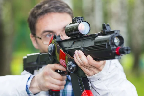 Muž míří pistolí laser tag zařízení. — Stock fotografie