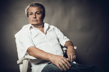 Gri arkaplanda orta yaşlı adam portresi.