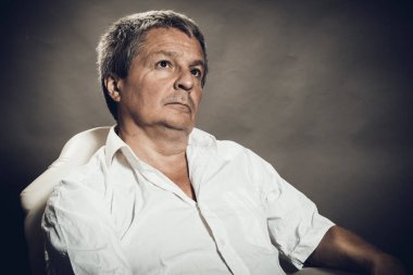 Gri arkaplanda orta yaşlı adam portresi.