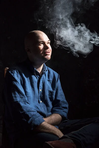 Hombre audaz y maduro fumando, retrato sobre fondo negro. — Foto de Stock