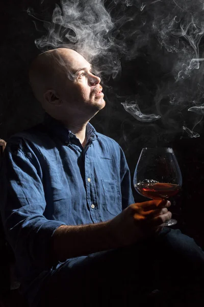 Solide kale man in shirt met glas whisky en rook studio portret. — Stockfoto