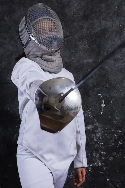 Tiener meisje fencer gekleed in uniform met epee en helm — Stockfoto