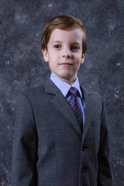 Aranyos iskolás fiú öltönyben. — Stock Fotó