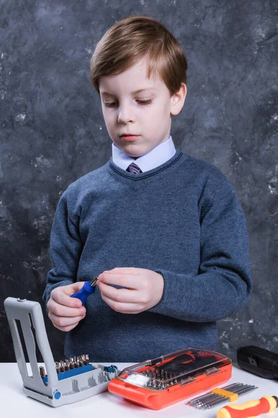 Çalışan aletlerle yakışıklı çocuk stüdyo portresi. — Stok fotoğraf