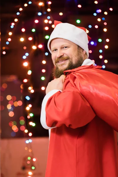 Γενειοφόρος άνδρας ντυμένος με κοστούμι Άγιος Βασίλης με δώρα — Φωτογραφία Αρχείου