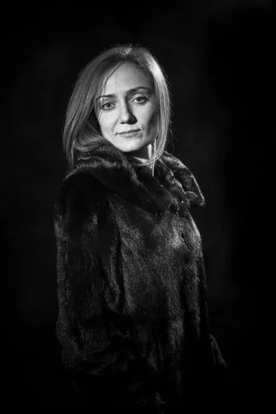 Pretty young woman dressed in fur coat — Stock Photo, Image