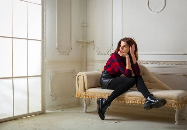 Portret van jonge mooie vrouw zittend op de bank — Stockfoto