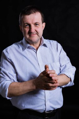 Tişört stüdyo resmi giymiş orta yaşlı, sağlam bir adam.