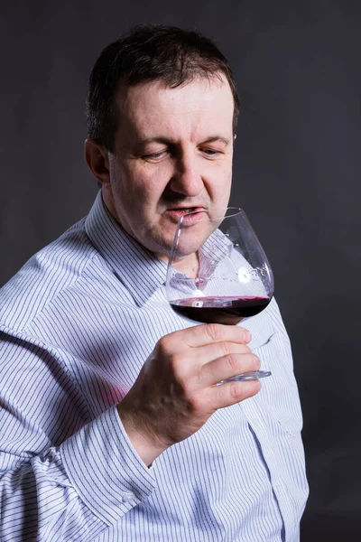 Fröhlicher Mann mittleren Alters in einem Hemd mit einem Glas Wein — Stockfoto