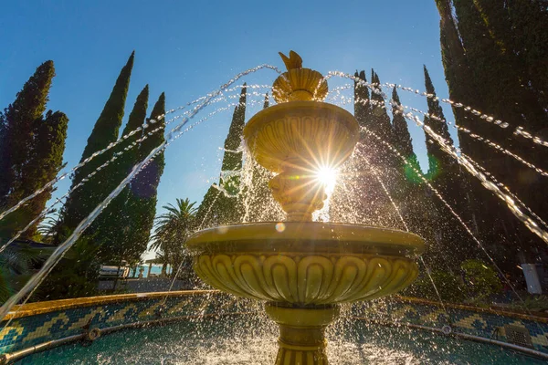 Scène met fontein en waterstralen spurt door de zonnestralen — Stockfoto