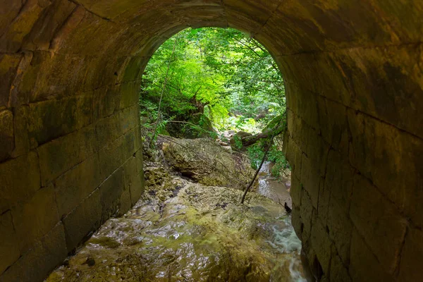 渓流を渡る古い石造りの橋のアーチ — ストック写真