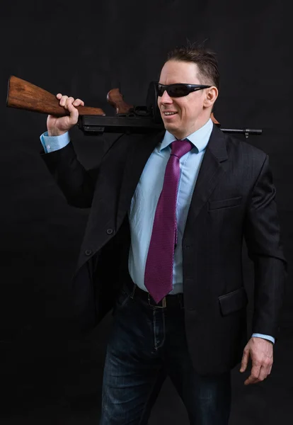 Volwassen gangster in zonnebril gekleed in pak met tommy gun — Stockfoto