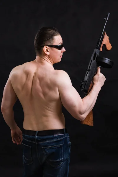 Uomo maturo in occhiali da sole e torso nudo con pistola tommy — Foto Stock