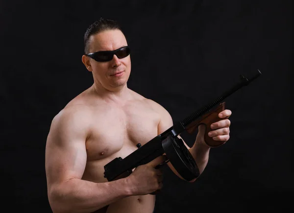 Ώριμος άντρας με γυαλιά ηλίου και γυμνό κορμό με το όπλο Tommy — Φωτογραφία Αρχείου