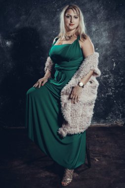 Yeşil elbiseli çekici, tombul kadın stüdyo portresi..