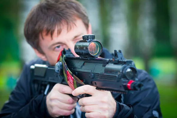Muž míří pistolí laser tag zařízení. — Stock fotografie