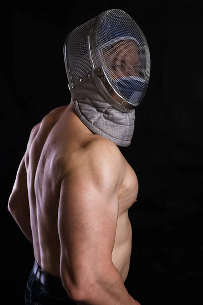 Homem em destaque com tronco muscular nu no capacete de esgrima — Fotografia de Stock