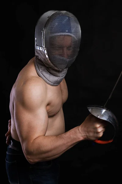 Homem em destaque com torso muscular nu em esgrima capacete e epee — Fotografia de Stock