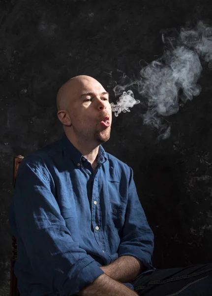 Hombre calvo maduro fumando, retrato sobre fondo negro. — Foto de Stock