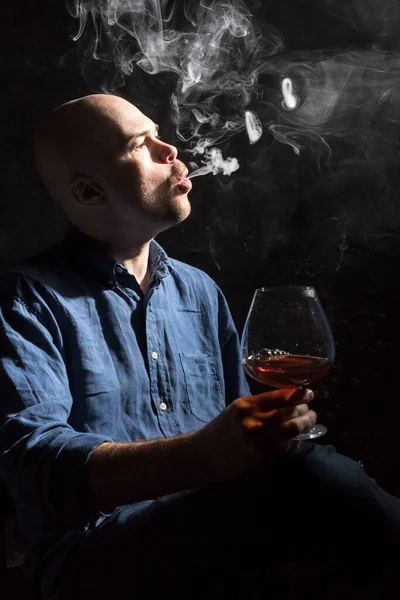 Vaste kale man in shirt met glas whisky en rook — Stockfoto