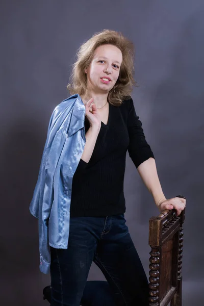 Cheerful 40 years old woman dressed in blue jeans and azure jacket — Stock Photo, Image