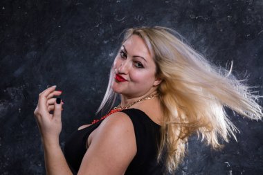 Çekici, tombul, dalgalı saçlı stüdyo portresi olan bir kadın..