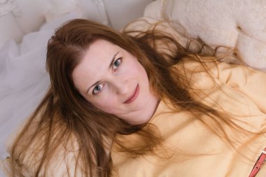 Çekici yaşlı kadın kanepeye uzanıp kameraya bakıyor.