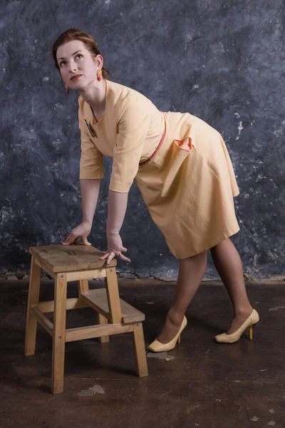 Cheerful middle aged woman dressed in beige dress studio portrait. — Stock Photo, Image