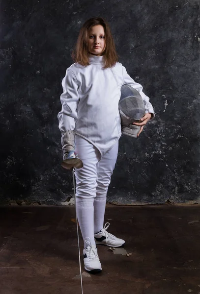 Tiener meisje fencer gekleed in uniform met epee en helm — Stockfoto