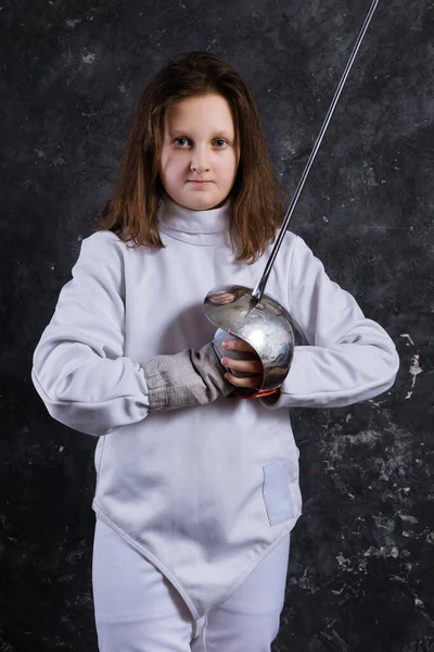 Teenage girl fencer dressed in uniform with epee and helmet — Stock Photo, Image