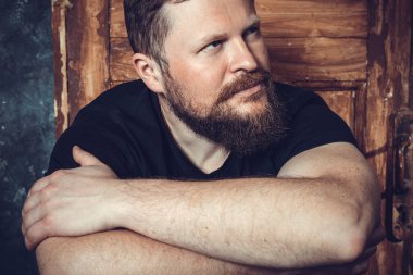 Olgun sakallı adam klasik kapının arkasında oturuyor.