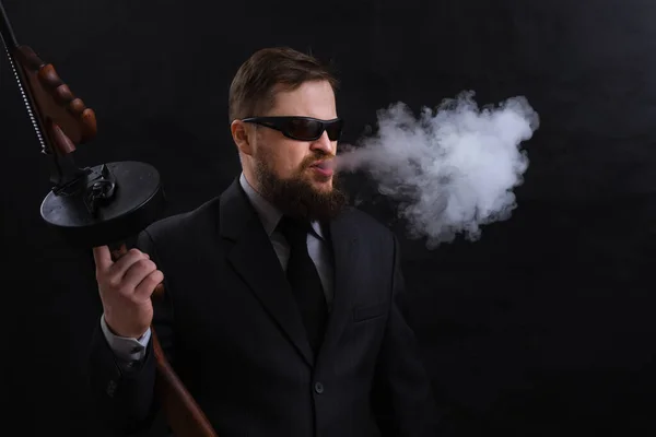 Ώριμος γενειοφόρος άνδρας με γυαλιά ηλίου ντυμένος με κοστούμι με το όπλο Tommy — Φωτογραφία Αρχείου