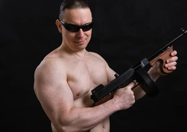 Ώριμος άντρας με γυαλιά ηλίου και γυμνό κορμό με το όπλο Tommy — Φωτογραφία Αρχείου