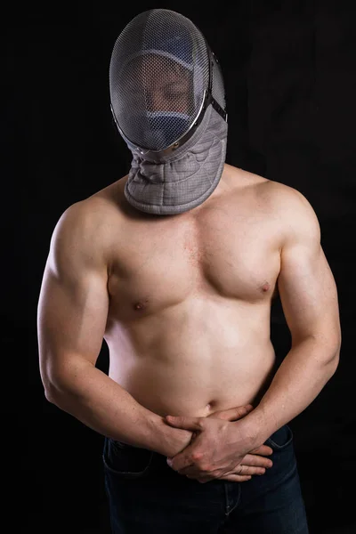 Matured man with naked muscular torso in fencing helmet — Stock Photo, Image