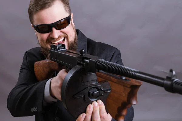 Hombre maduro en gafas de sol vestido de traje con pistola Tommy —  Fotos de Stock