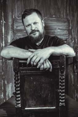 Olgun sakallı adam klasik kapının arkasında oturuyor.